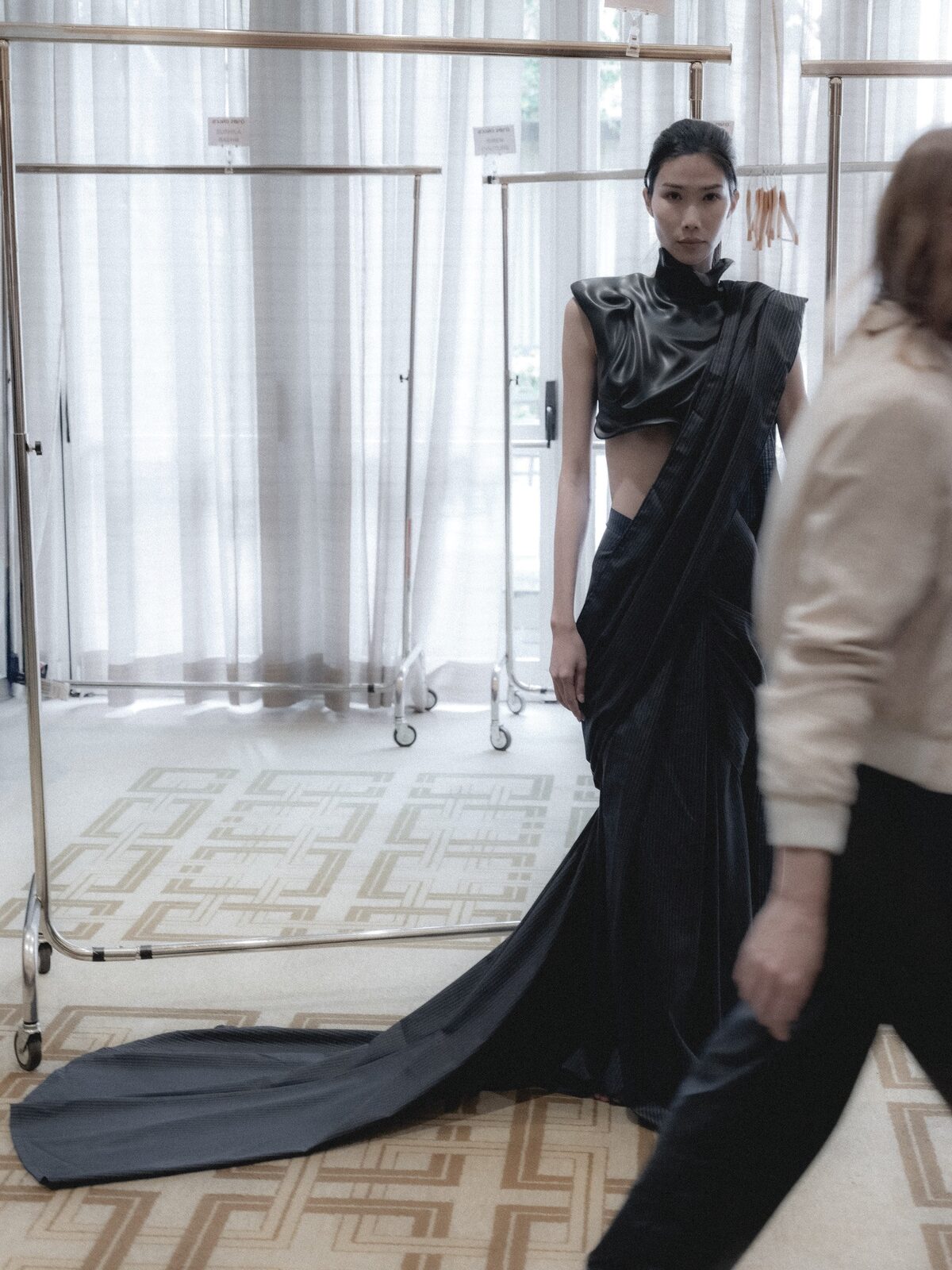 a model in a long black dress at a fitting