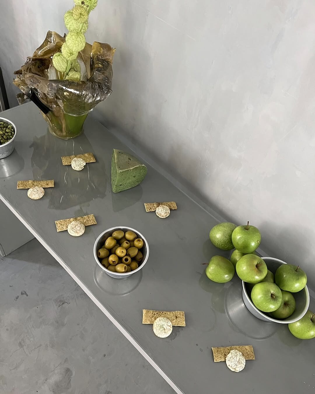 green apples and small objects along a concrete table