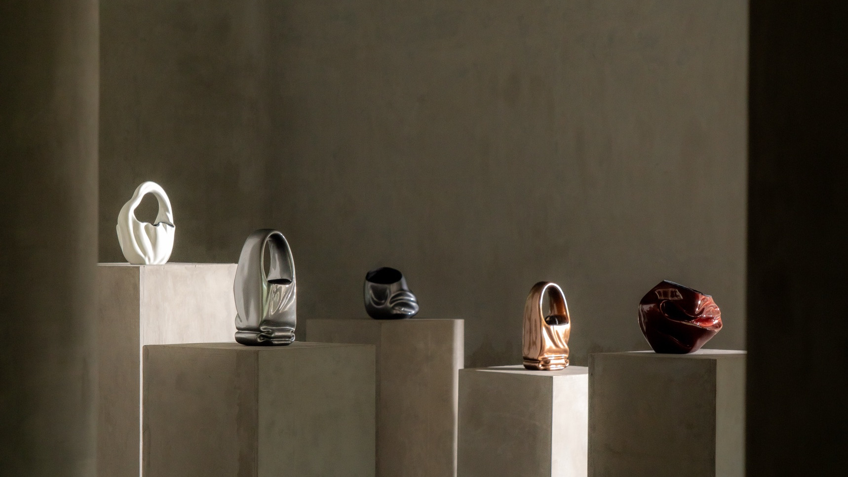 architectural digest india: devanshi jain sculptural bags on concrete plinths in the studio