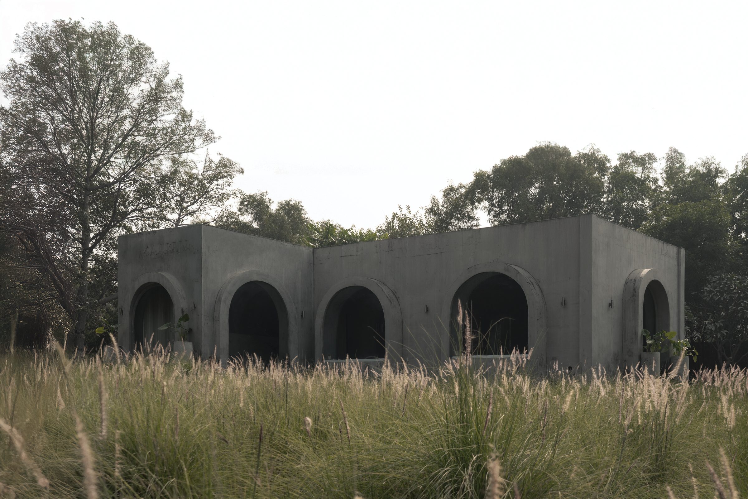 the delhi studio: a 1970s concrete structure of arches in a private forest