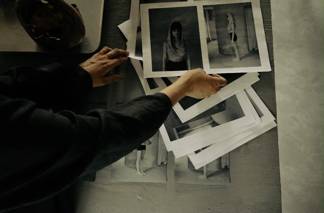 hands sorting black and white prints on the studio table