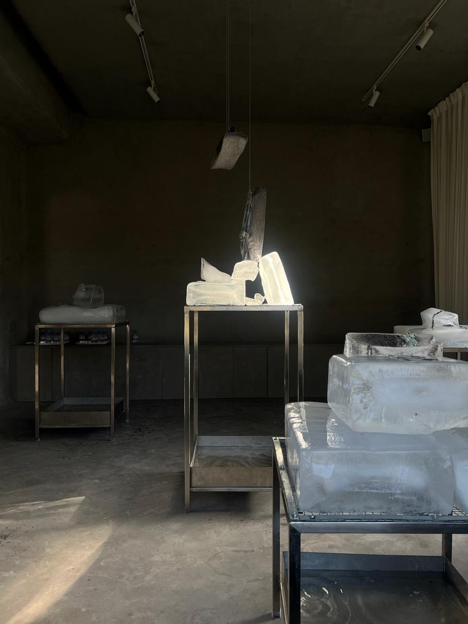 an installation of ice blocks on steel stands, lit by the afternoon sun