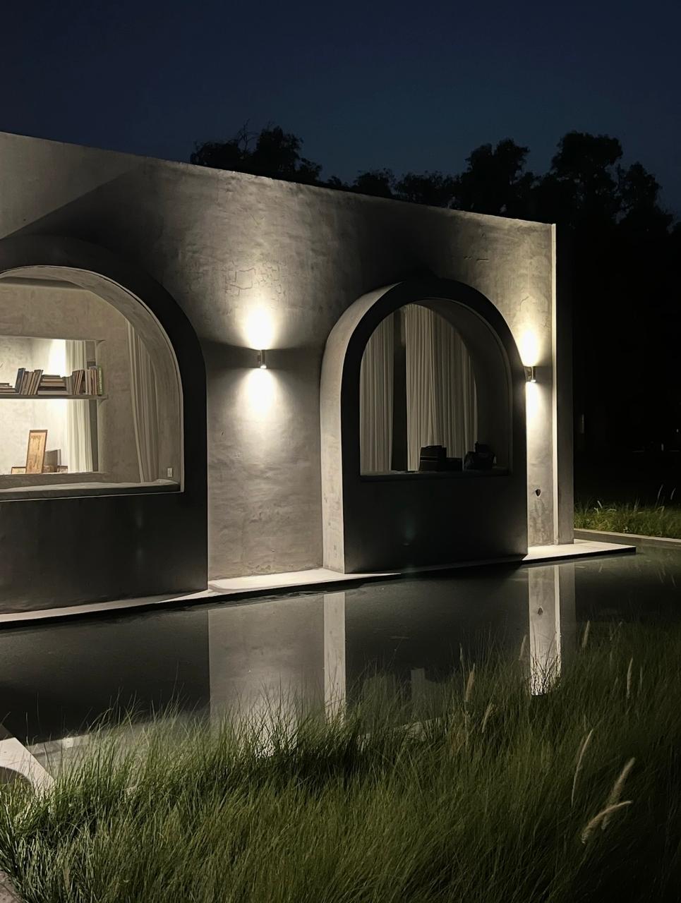 the arched windows lit at night over the reflecting pool