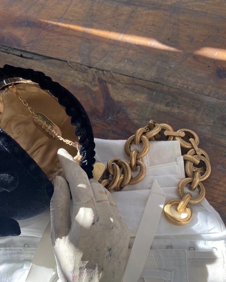 chrysalis opened, its gold lining and chain tag beside a gold chain