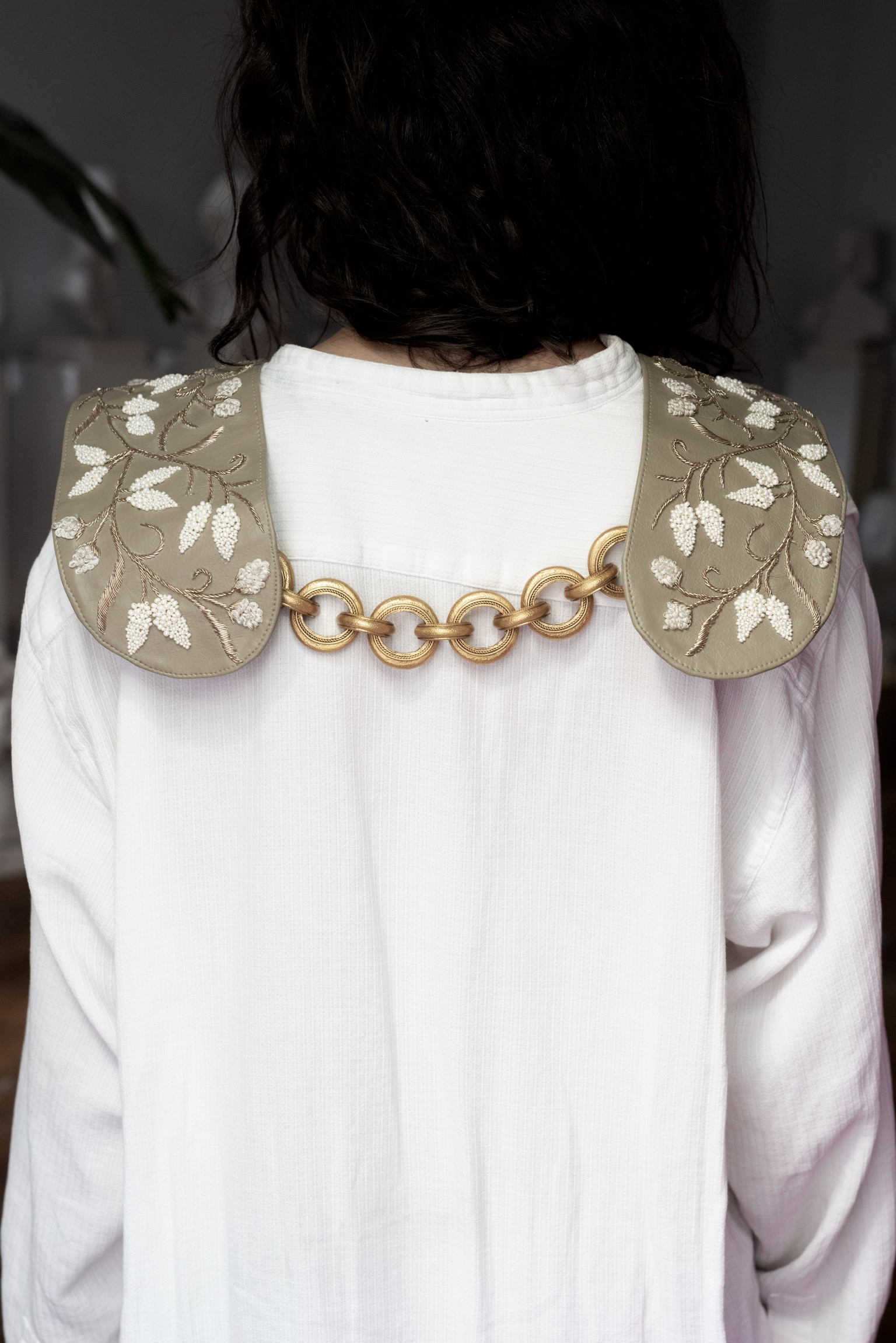 spero from behind: embroidered shoulder pieces joined by a gold chain